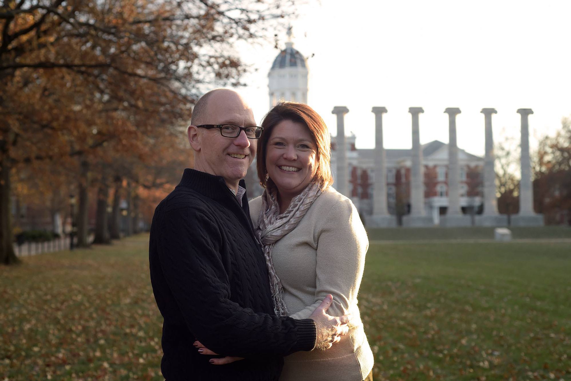 Megan and Stan Silvey pose for a photo on the quad. the columns are in the background