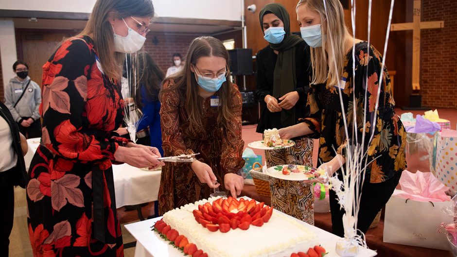 women cutting cake at a baby shower