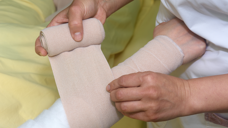 This is a photo of an arm getting wrapped with a bandage.