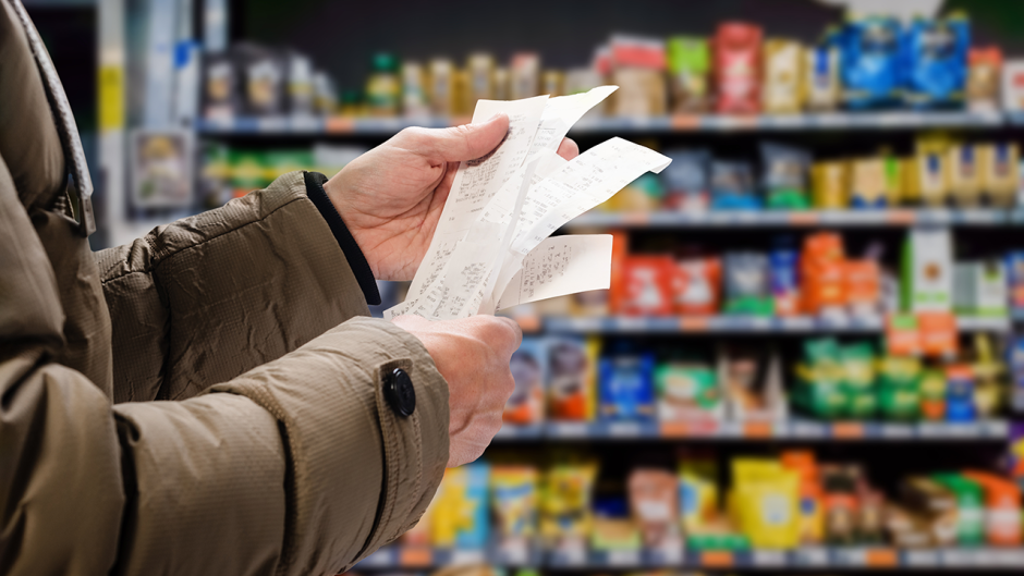 A photo of a person looking at a receipt in a grocery store (source: Shutterstock).