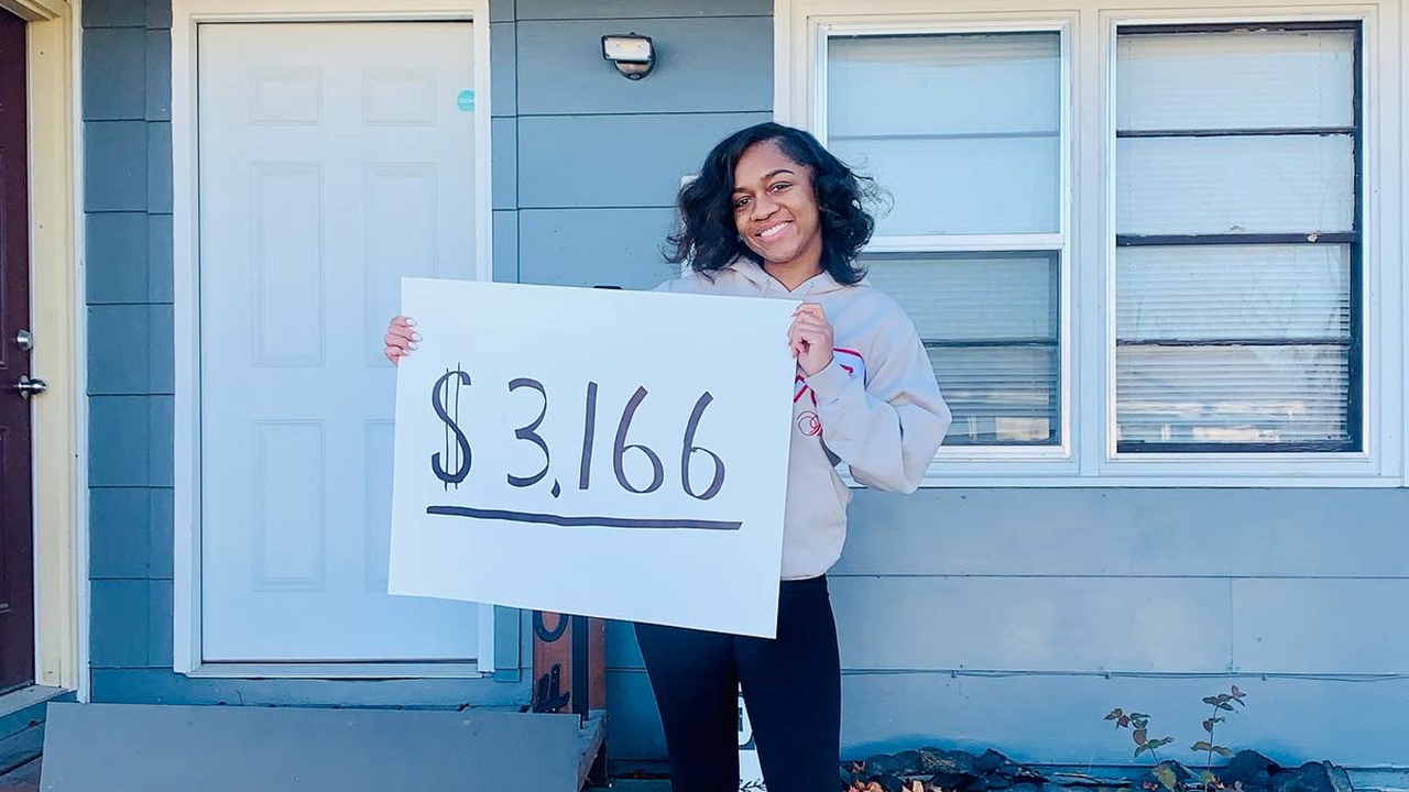 Alaina holding a sign that says $3,166