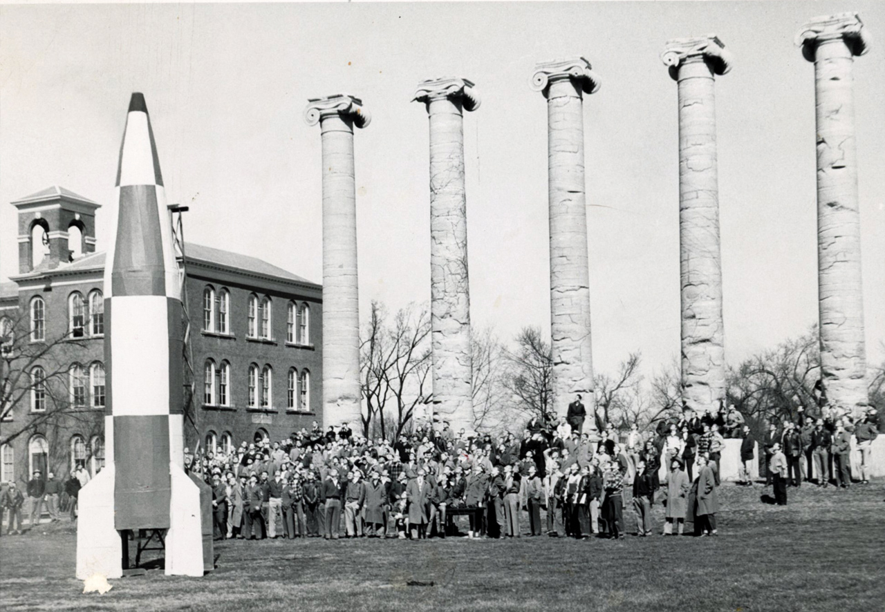 1950s students on quad with large rocket