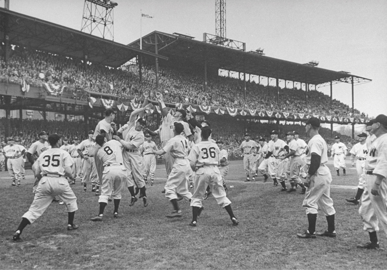 baseball players jumping for a ball