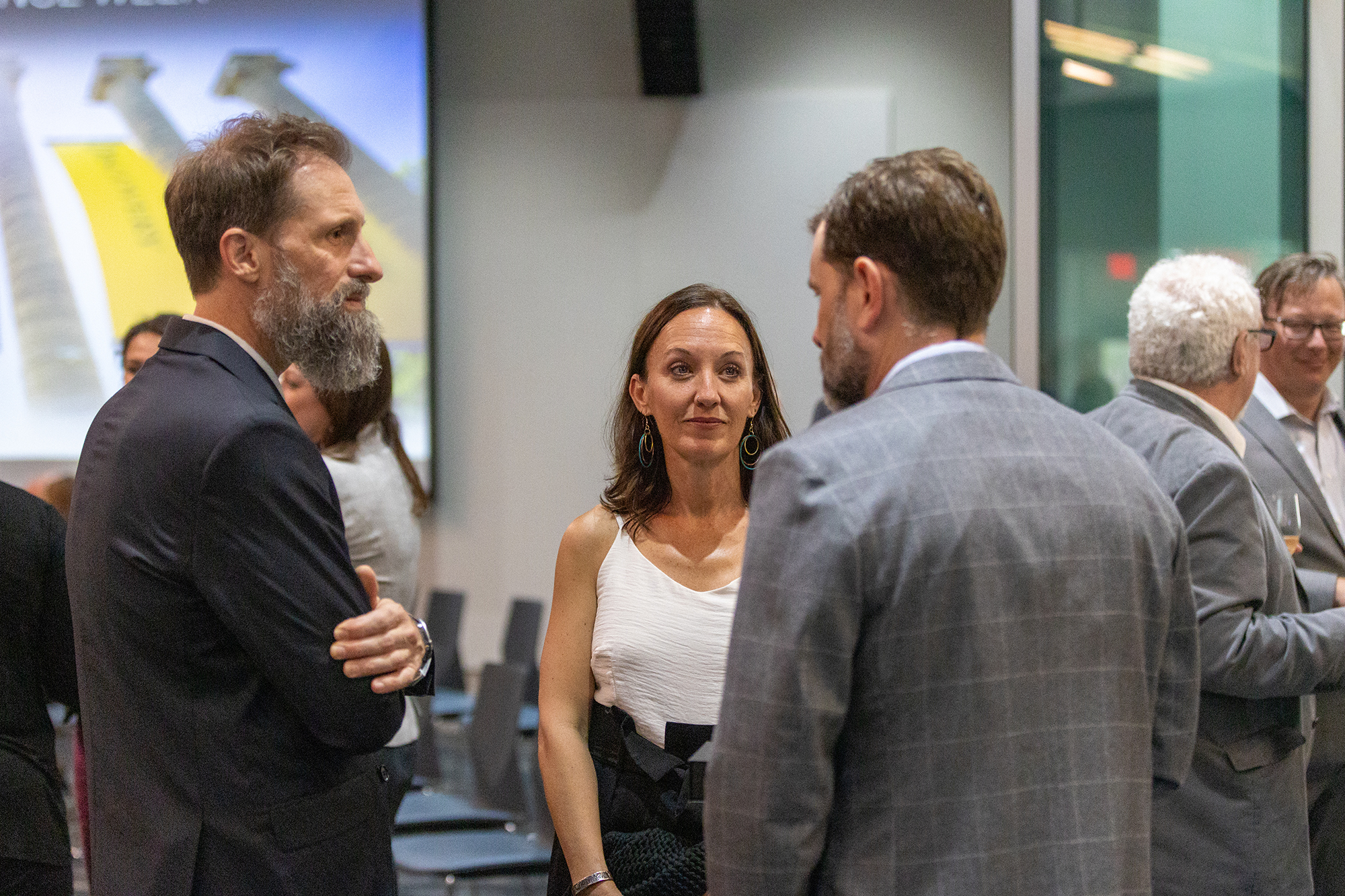 three people chat at an event reception