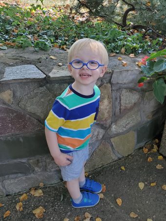 a little boy with blue glasses and blonde hair
