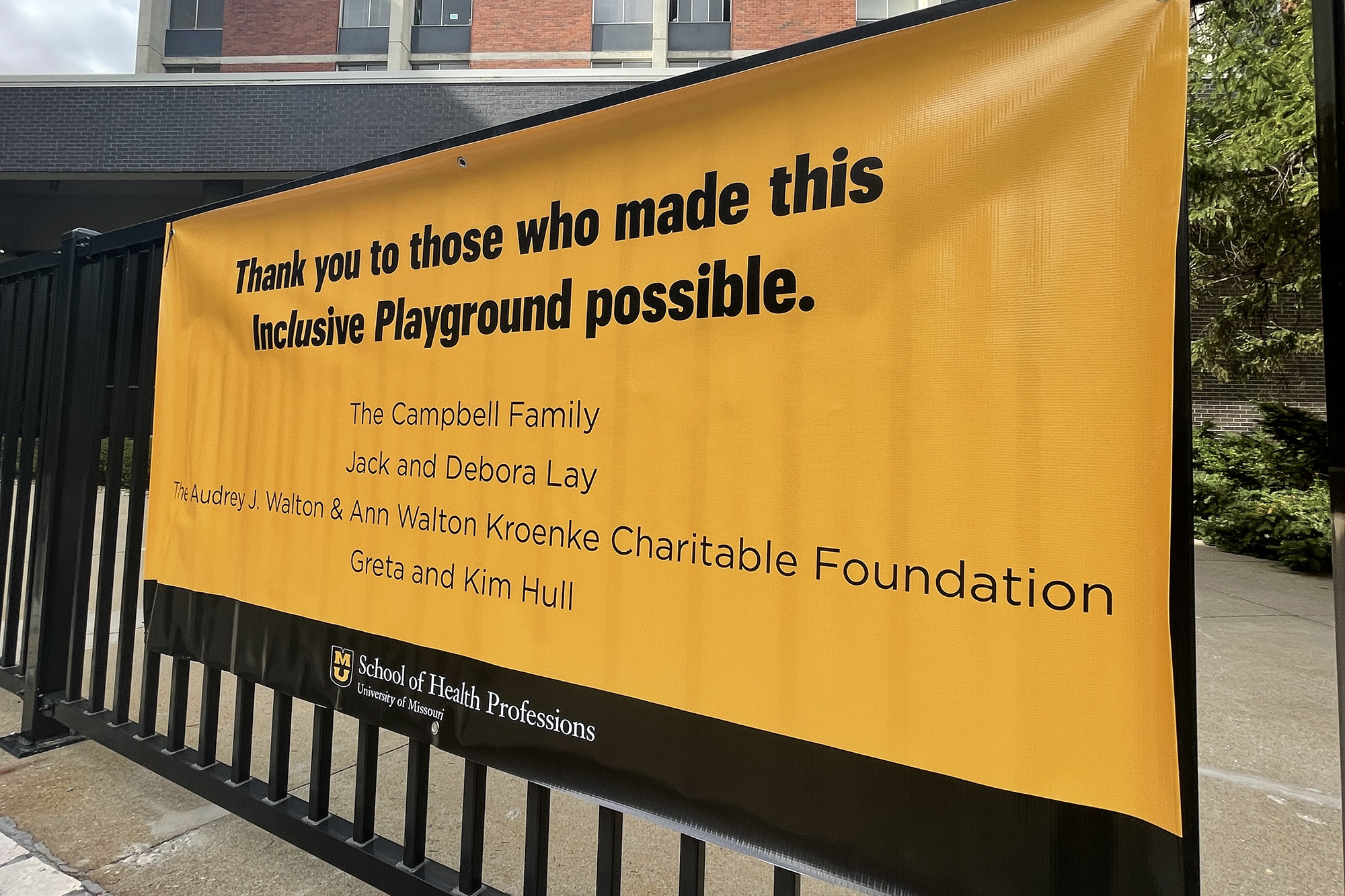 a sign that says "thank you to those who made this inclusive playground possible" and lists "the campbell family, jack and debora lay, the audrey j. walton & ann walton kroenke charitable foundation, greta and kim hull"