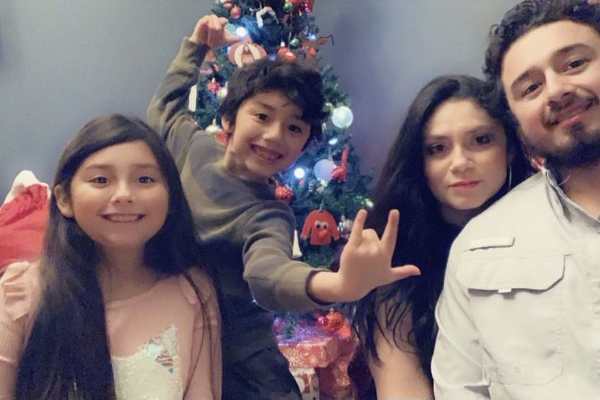 The Rodriguez family — Camilia, Maximus, Tania and Eric — stand in front of their Christmas tree.