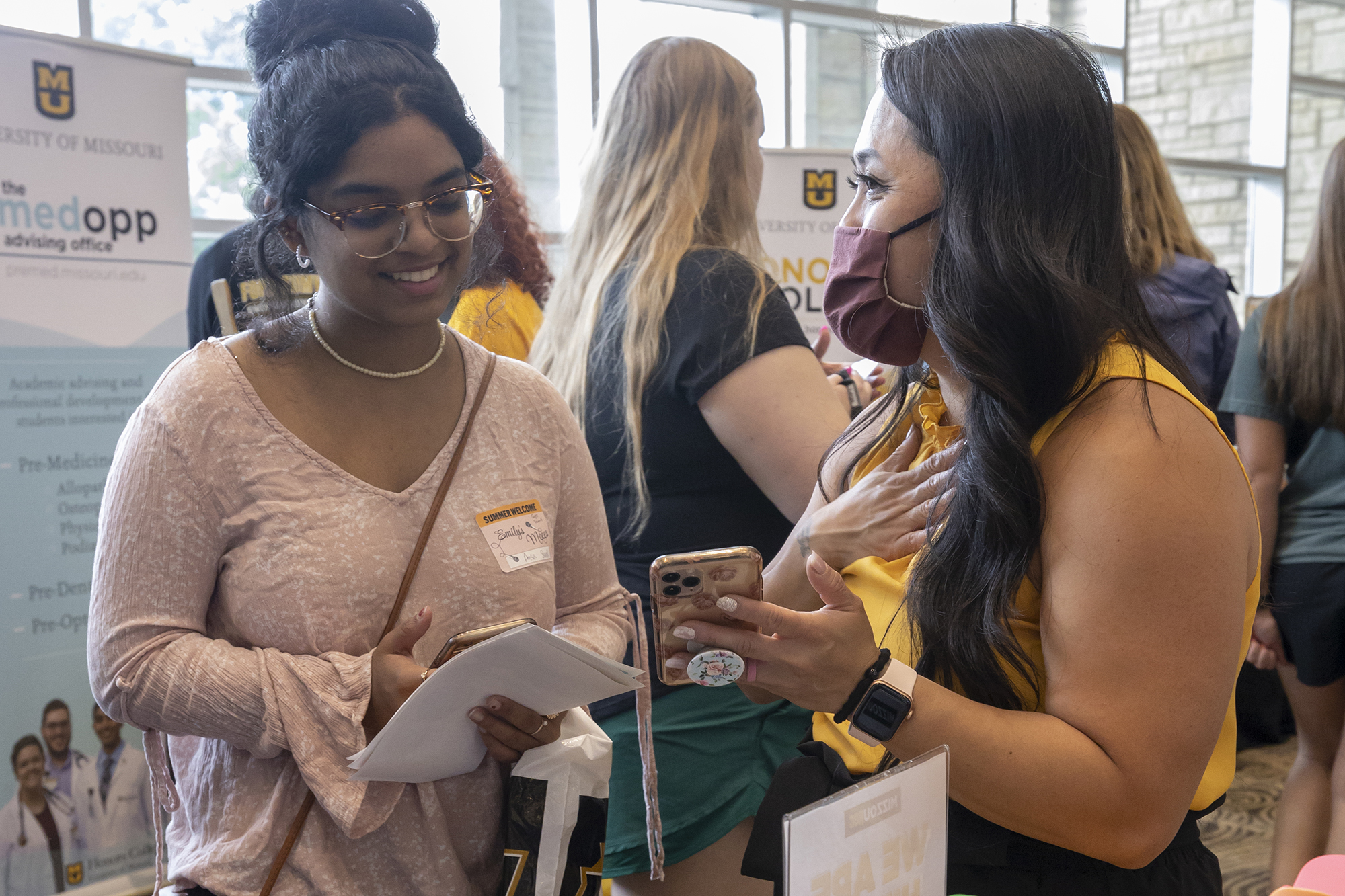 two women interact at an indoor fair