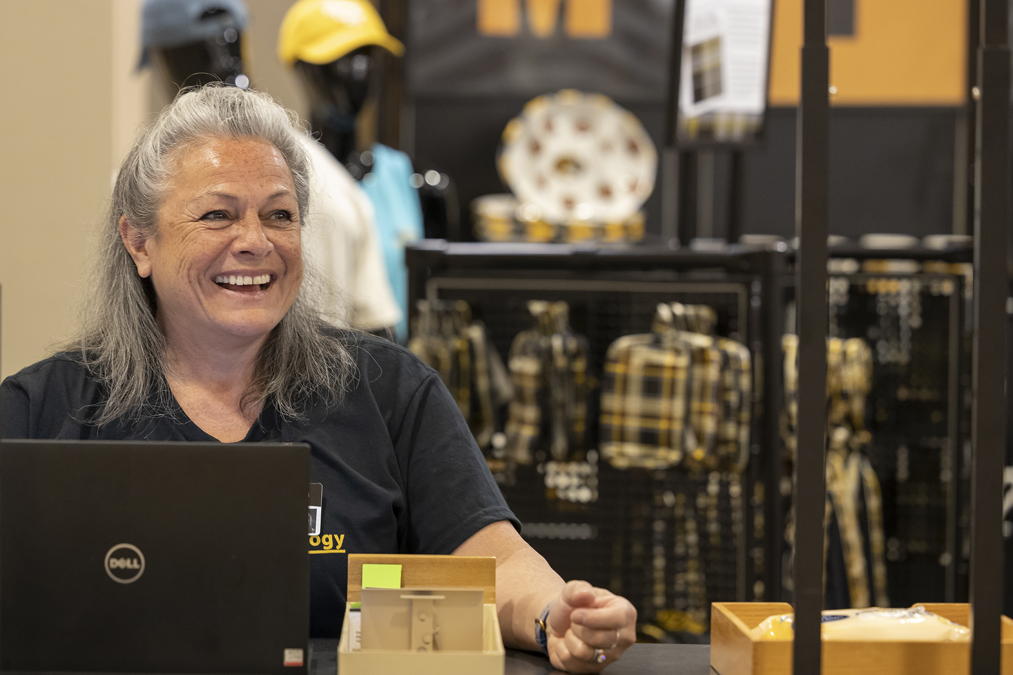 a woman smiles in front of the mizzou store