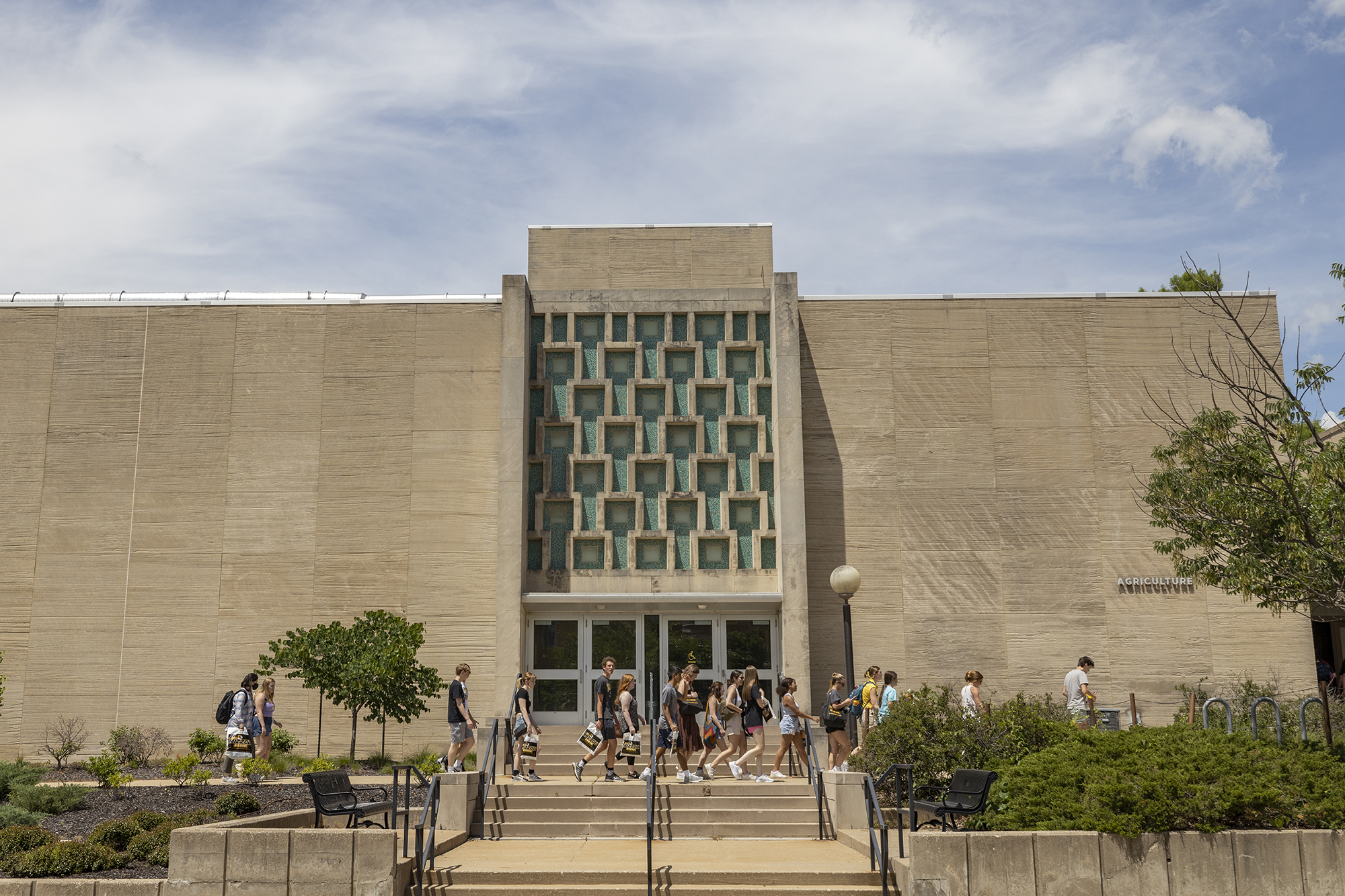 students outside in front of the agriculture building, walking toward a new destination