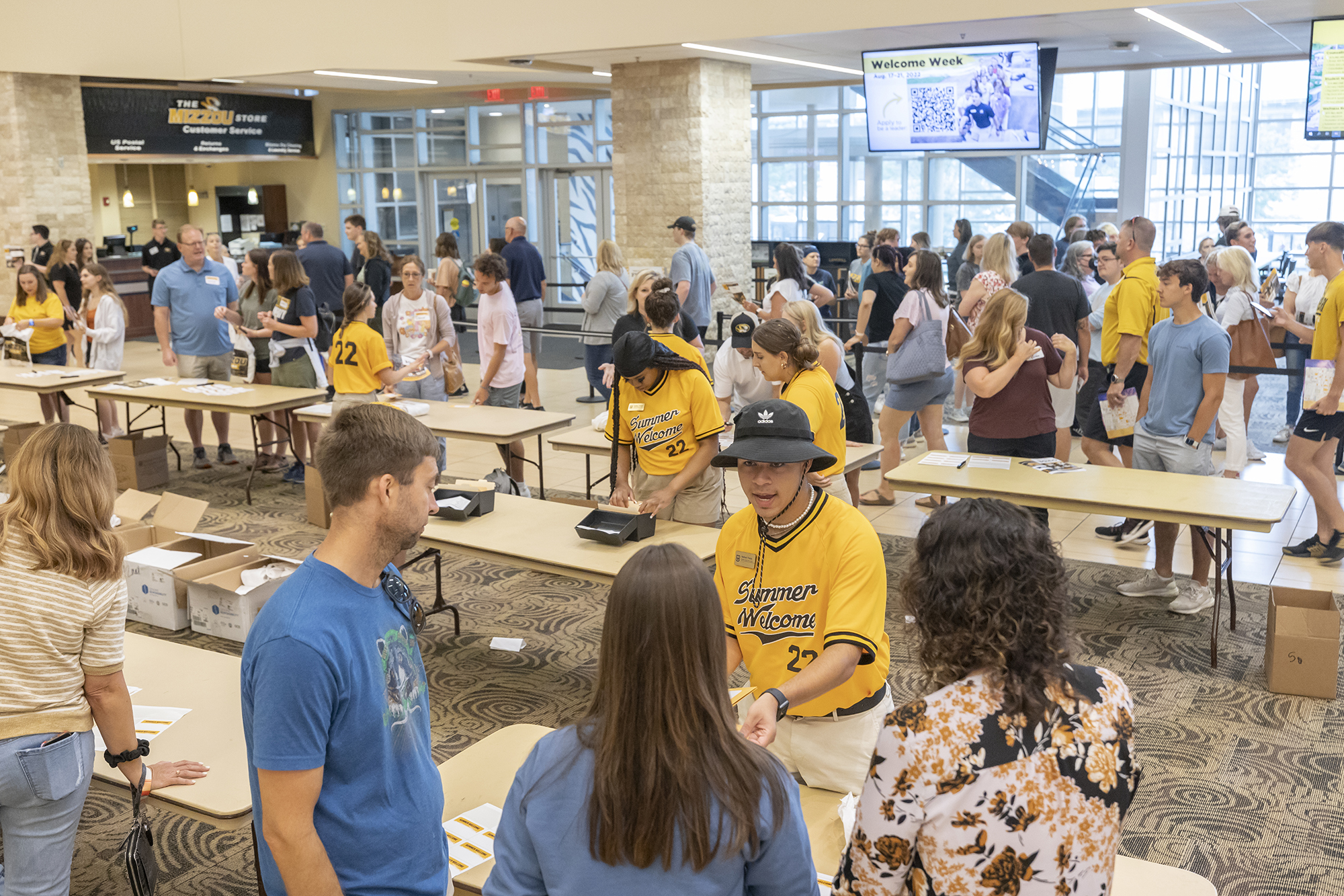 summer welcome leaders help new students at an information fair at the student center