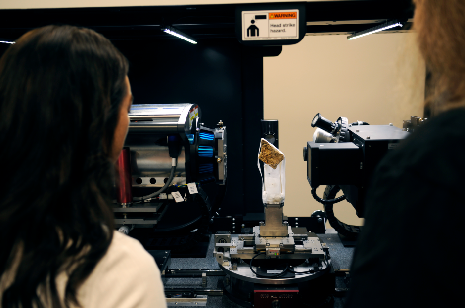 Picture of two people loading a rock sample into a lab machine