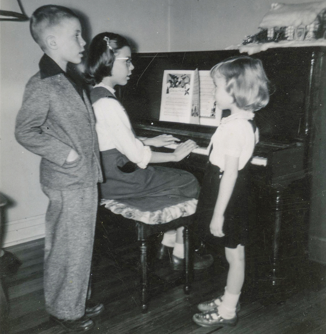 young siblings near piano