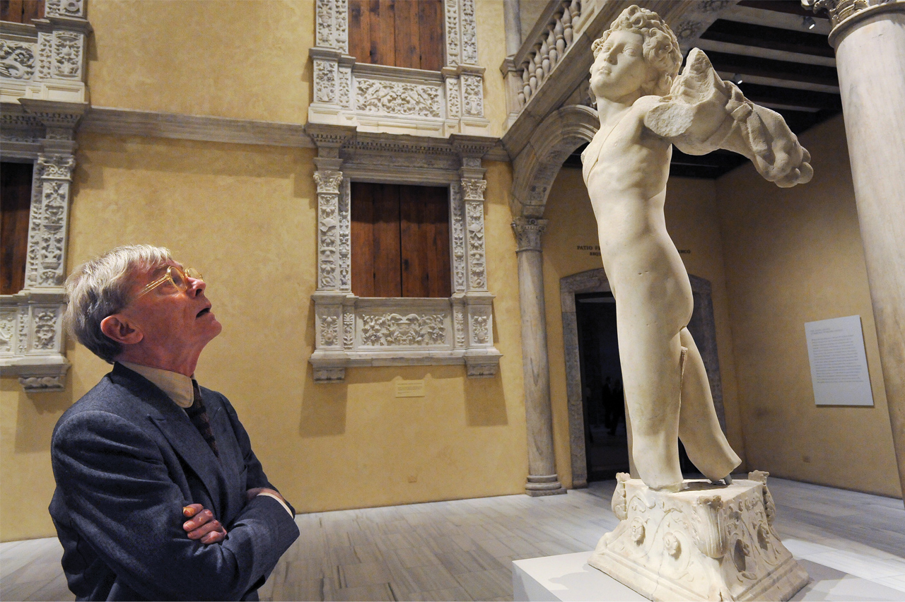 man looking at sculpture