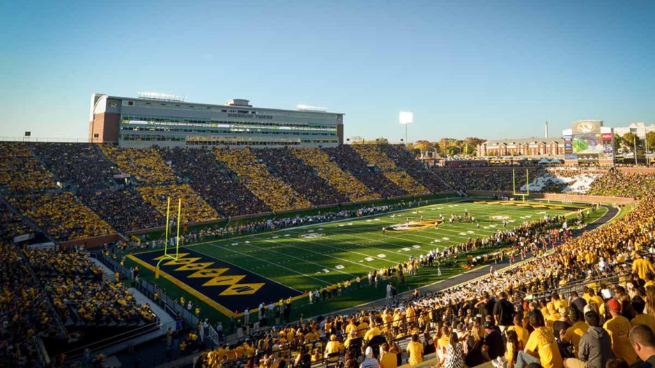 a mizzou football game with full stands wearing black and gold