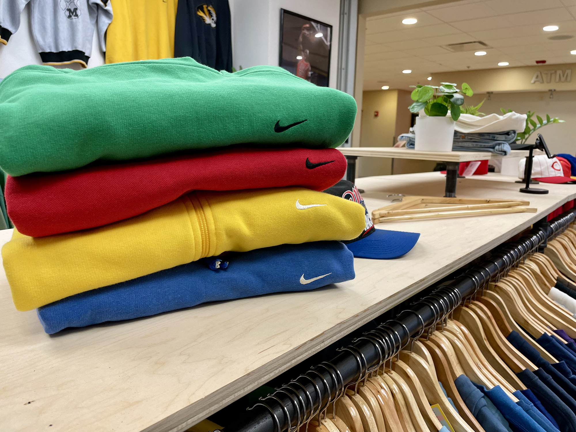 a stack of colorful sweatshirts in the aged ivy storefront
