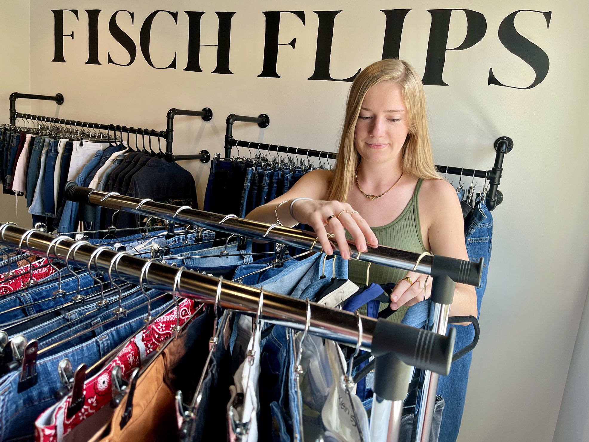 a woman organizes clothes on a rack