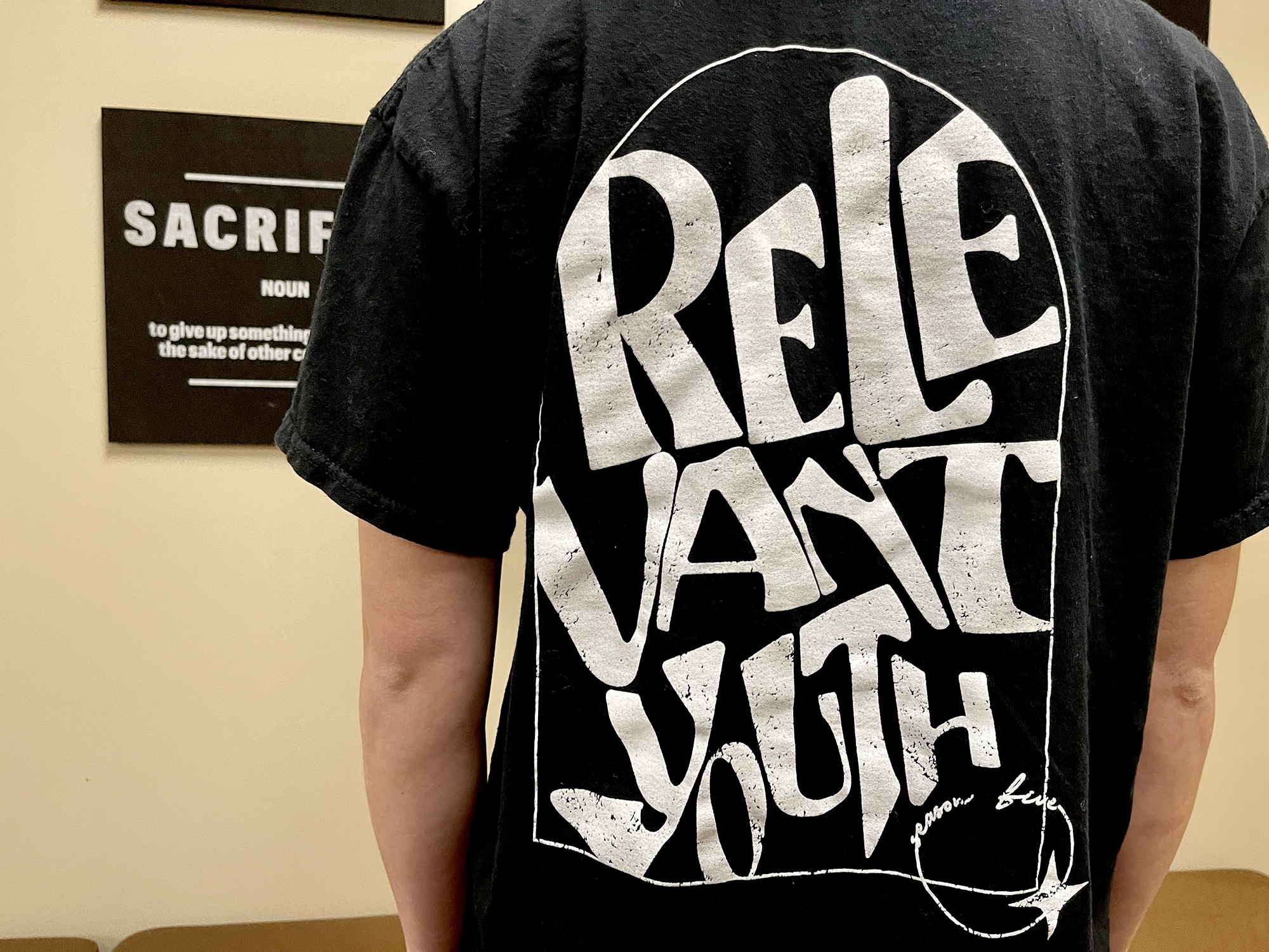the back of a black relevant youth t-shirt