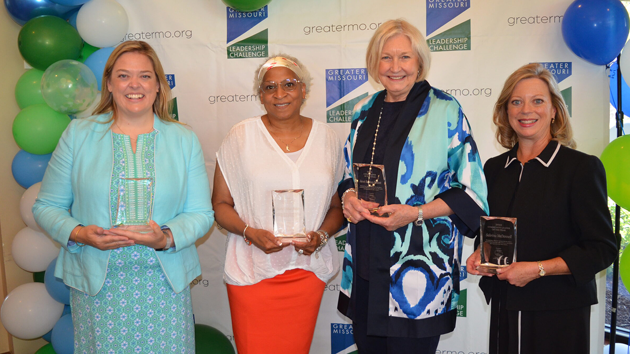 four women holding awards