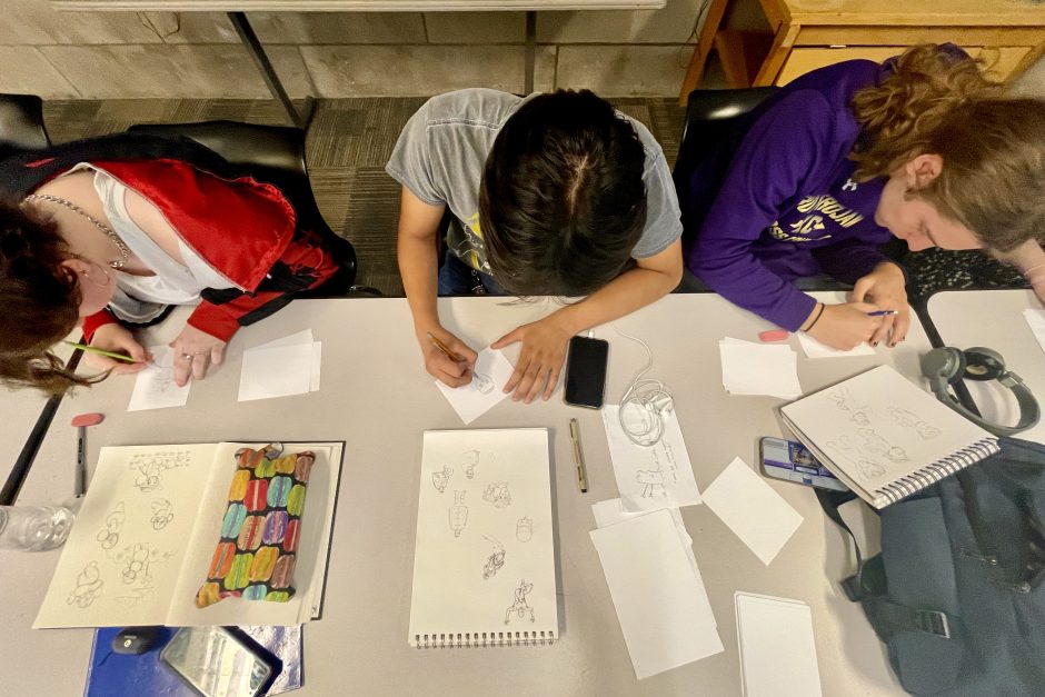 Overhead view of students drawing comics