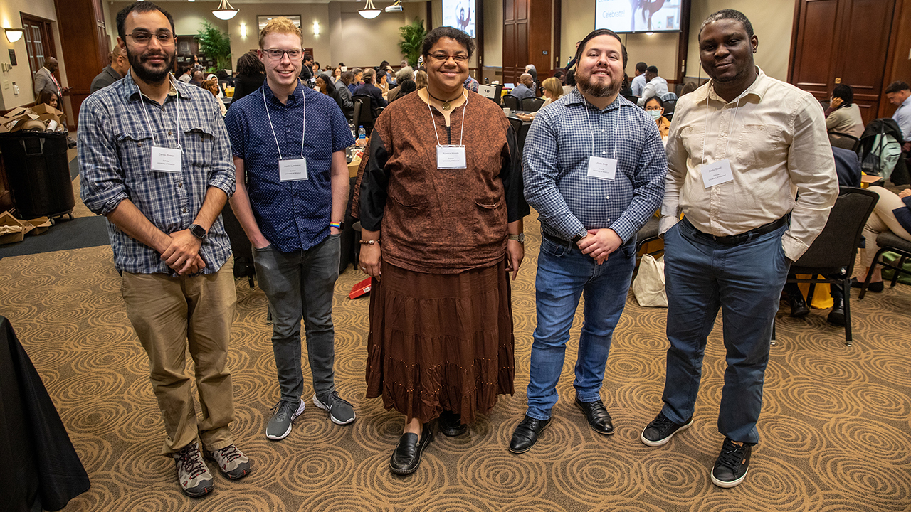 group photo of five students at a conference