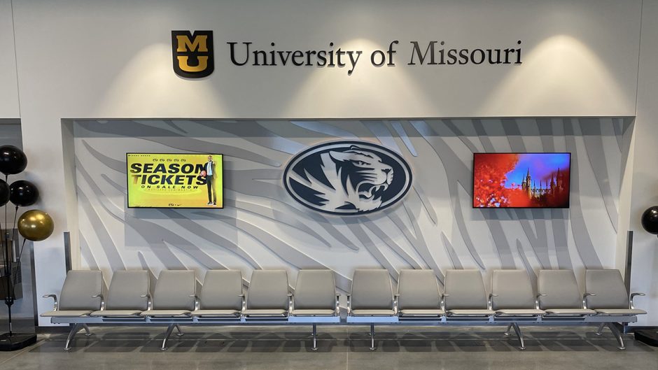 university of missouri logo above seats and tv screens at the new airport terminal