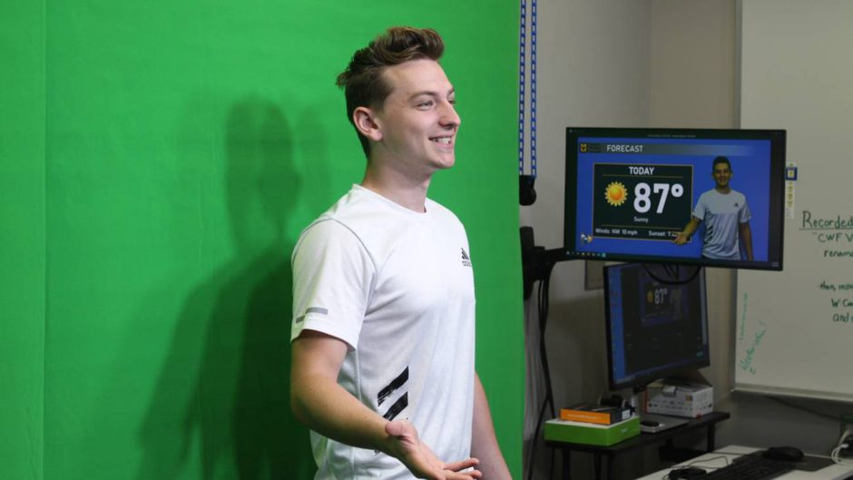 a student in front of a green screen in a weather lab