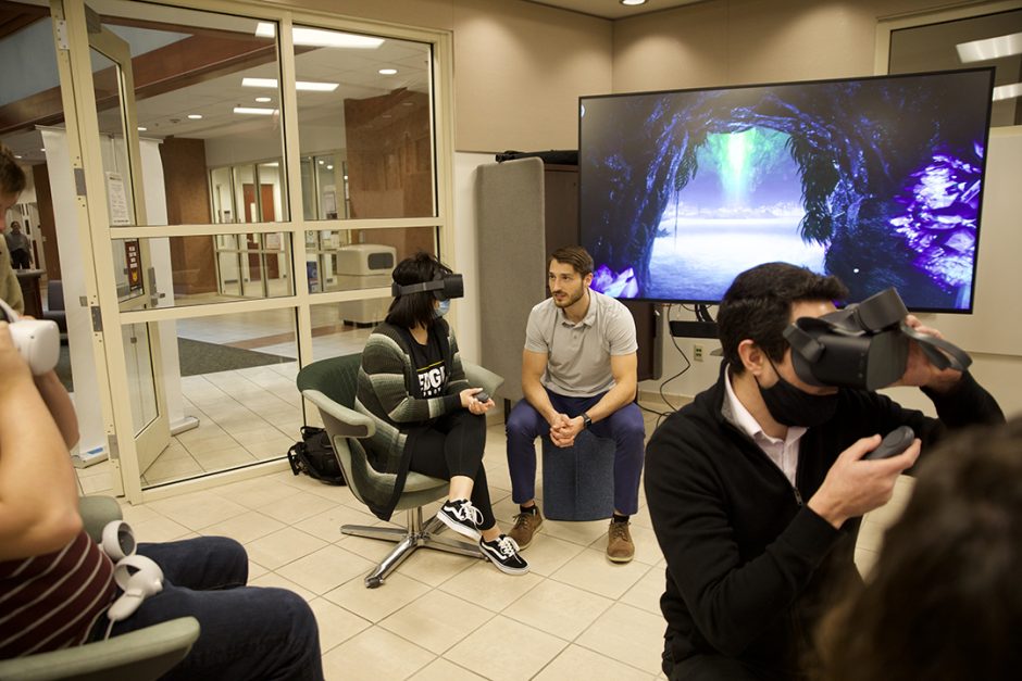 Students chat in the MU Innovation Space surrounded by virtual reality equipment