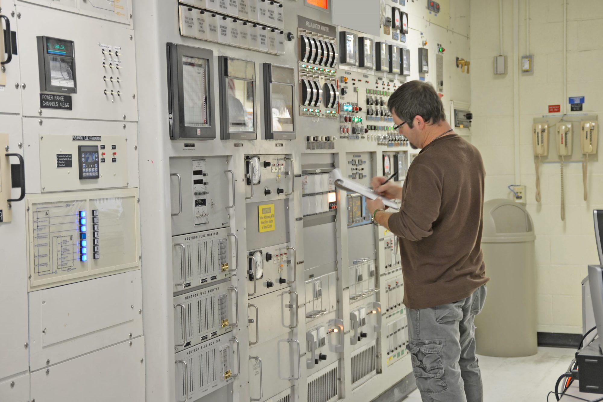 A reactor operator entering log data in the control room