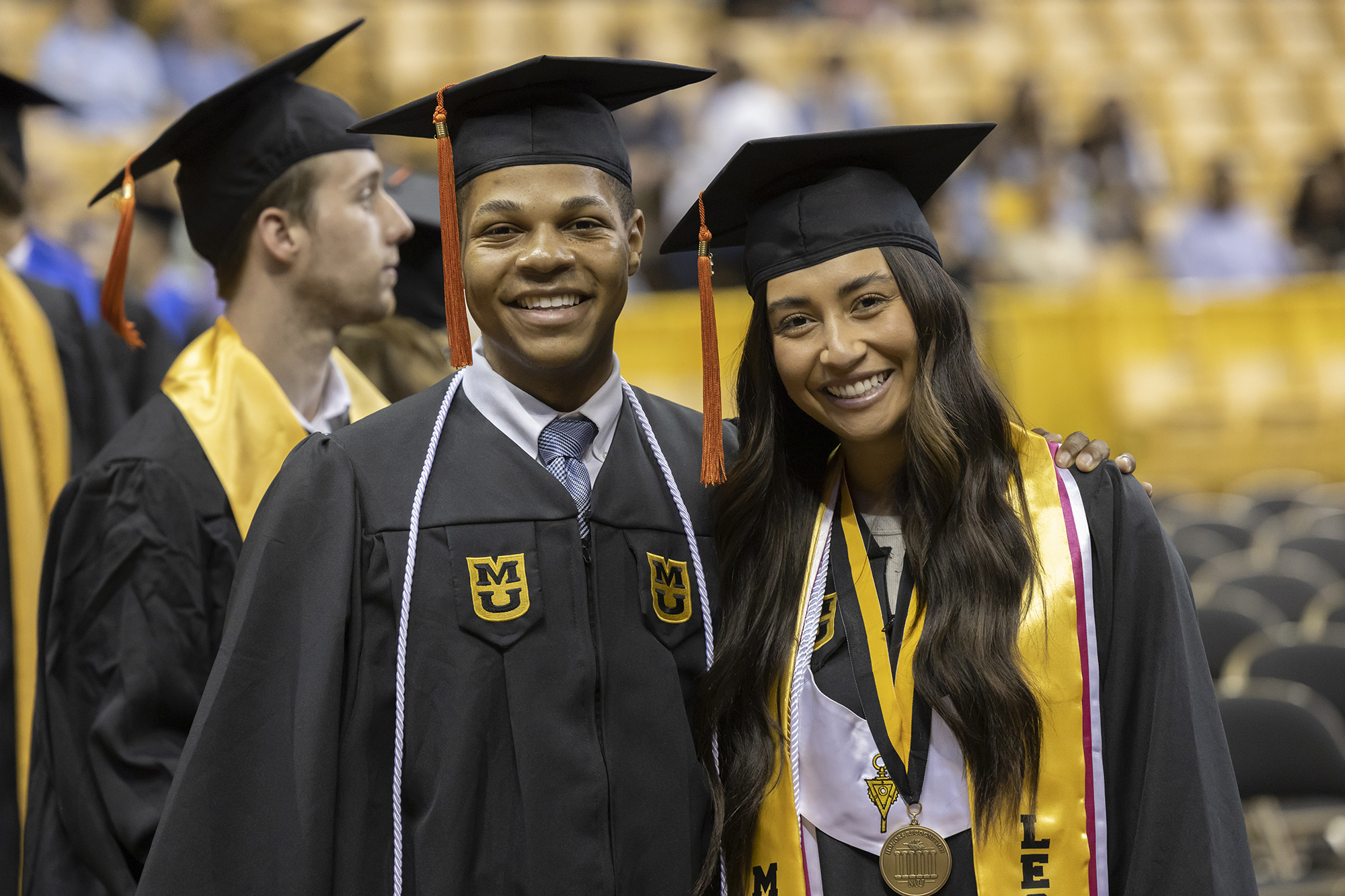 a man and woman smile at commencement