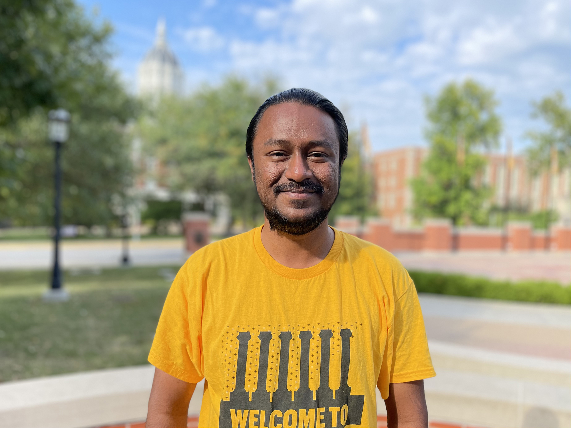 Mahendra in front of Jesse Hall in a gold Mizzou shirt