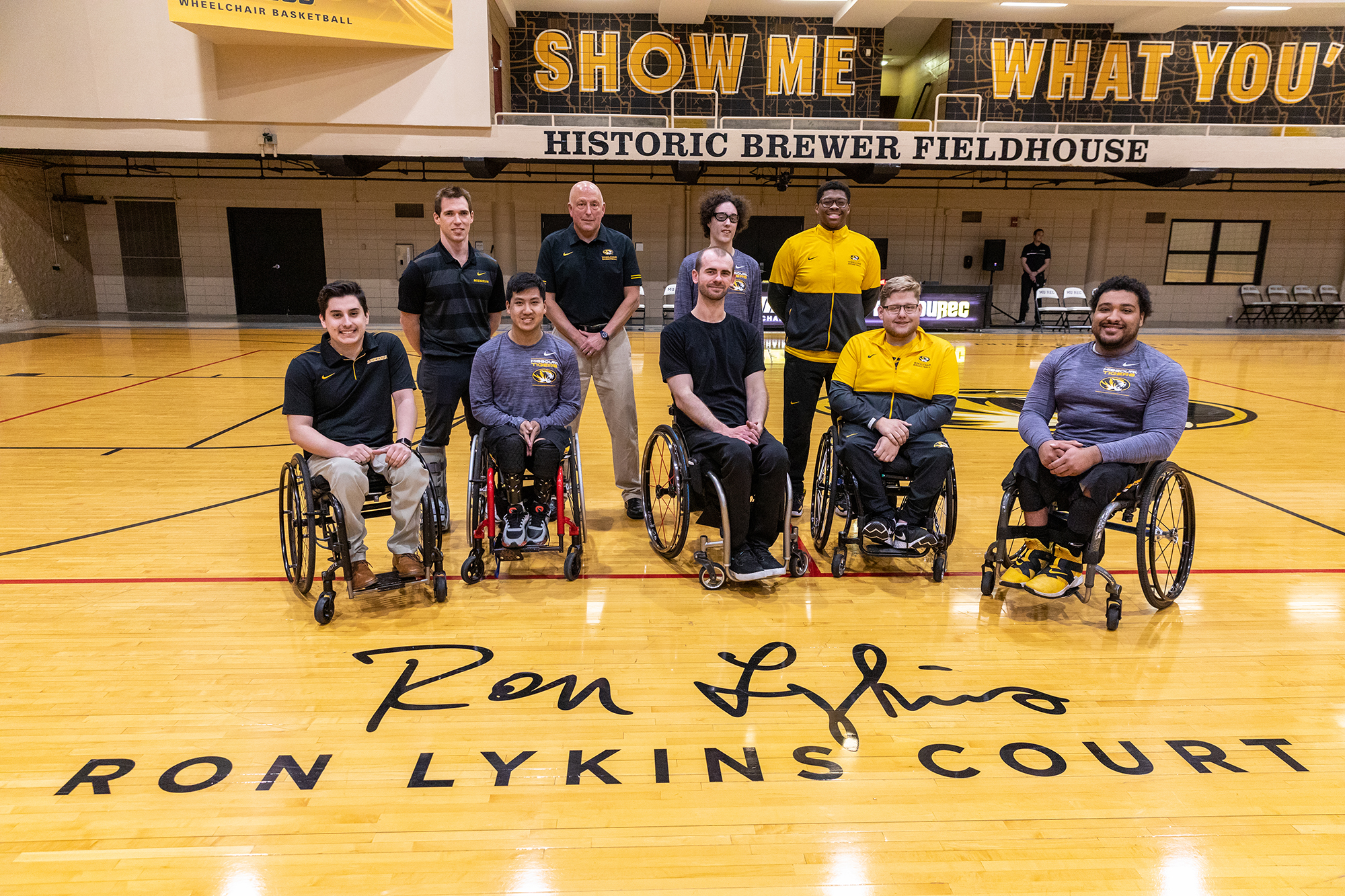 coach lykins and wheelchair basketball team members on the court