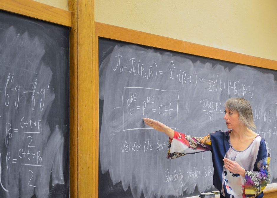 Woman teaches a class on a chalkboard