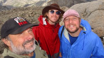 Picture of three men standing on top of a mountain