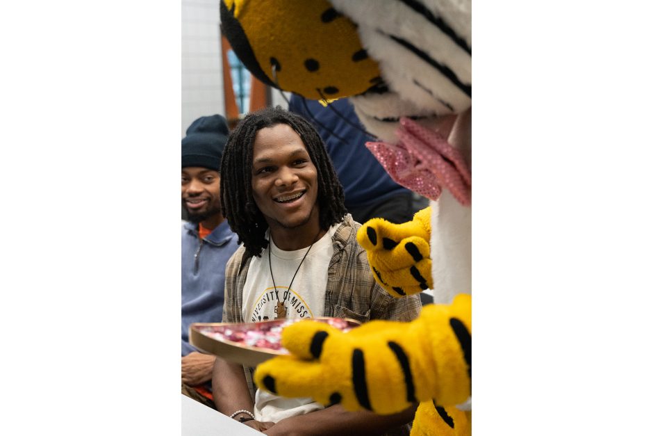 truman the tiger gives chocolates to a student