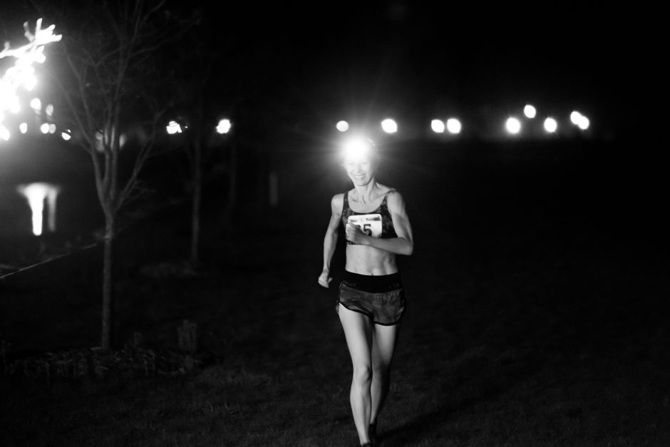 Woman running at night in a 24-hour competitive running event. 