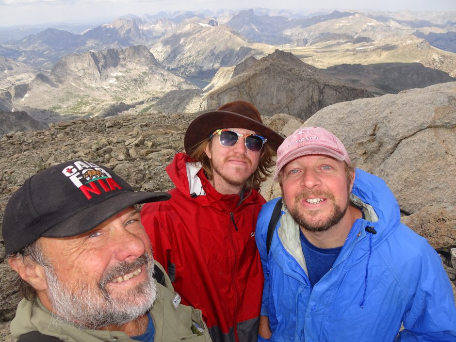Picture of three men standing on top of a mountain