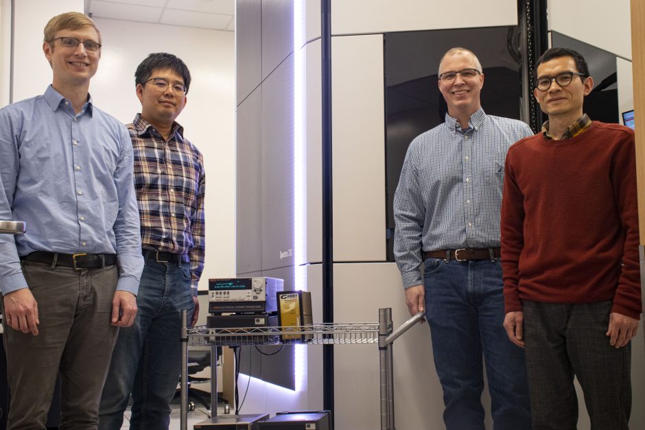 Portrait of researchers in front of an electron microscope 