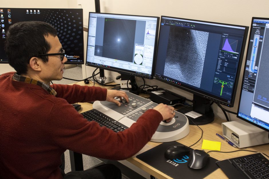 person works on multiple computer screens