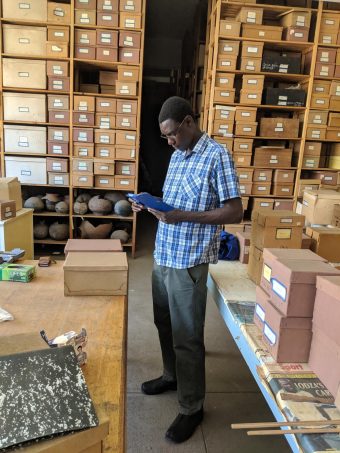 Man looks at folder inside the artifact collections room at a museum in Africa
