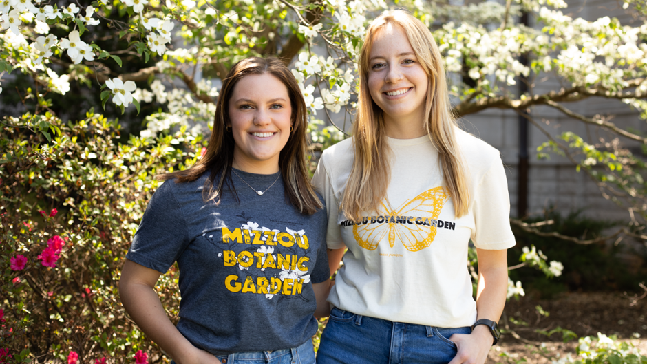 two girls smile in mizzou botanic garden shirts outside