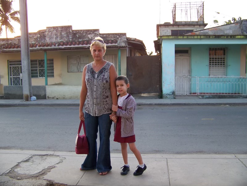 Débora Paez Perez (right) and her mom, Janet (left), photographed in front of their home in Cuba.