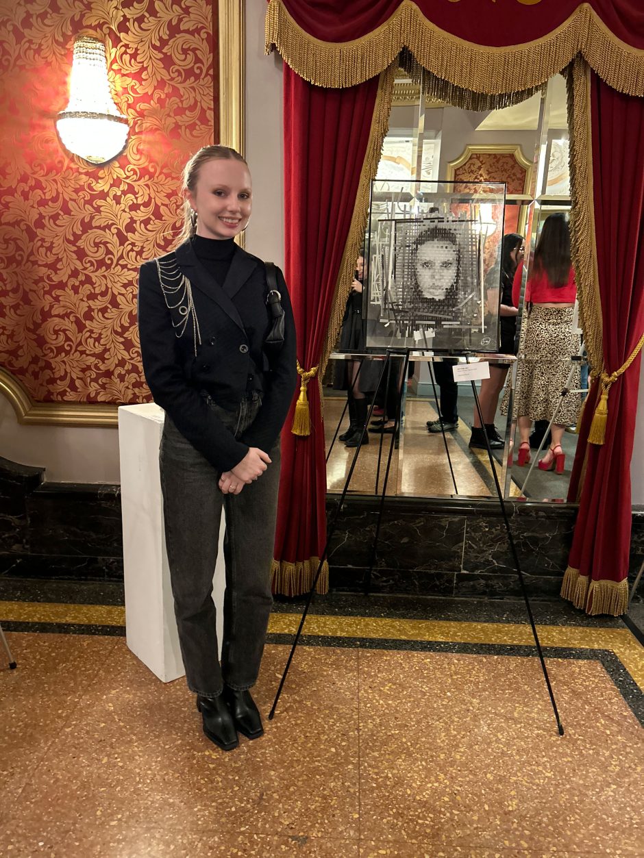 Samantha Novak standing next to her artwork