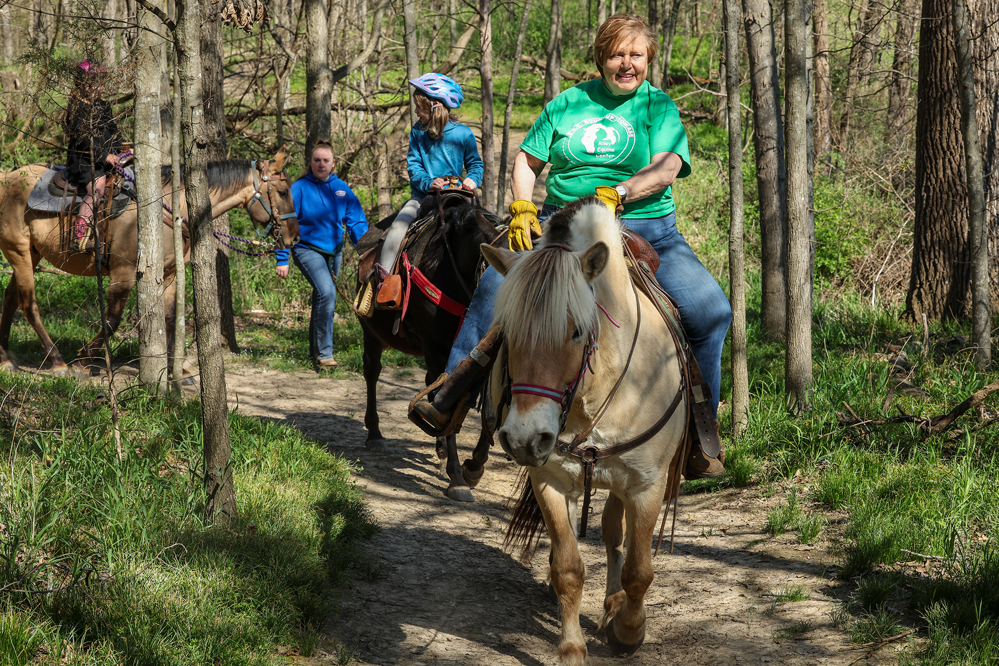 Group on horseback rides on trail