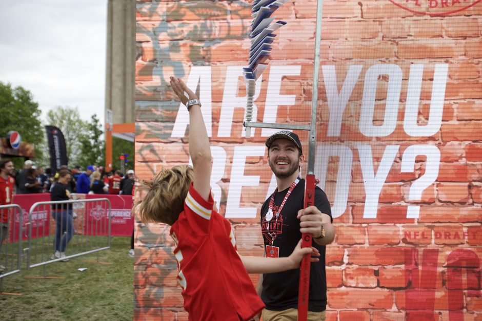 Sam Gnolfo holds the vertical-jump testing pole for a young participant.