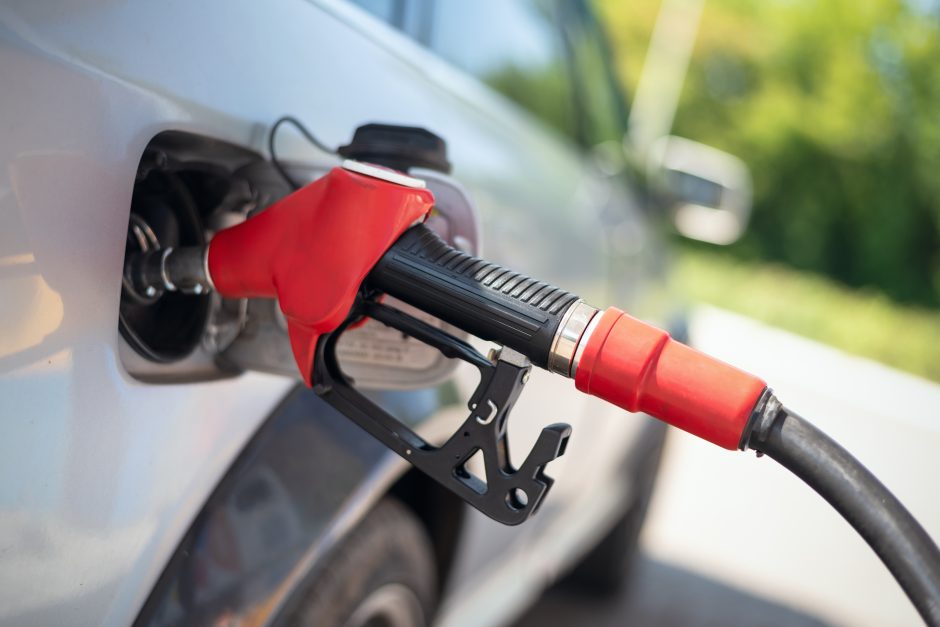 A red colored gasoline pump connected to a silver car's gas tank. Source Shutterstock