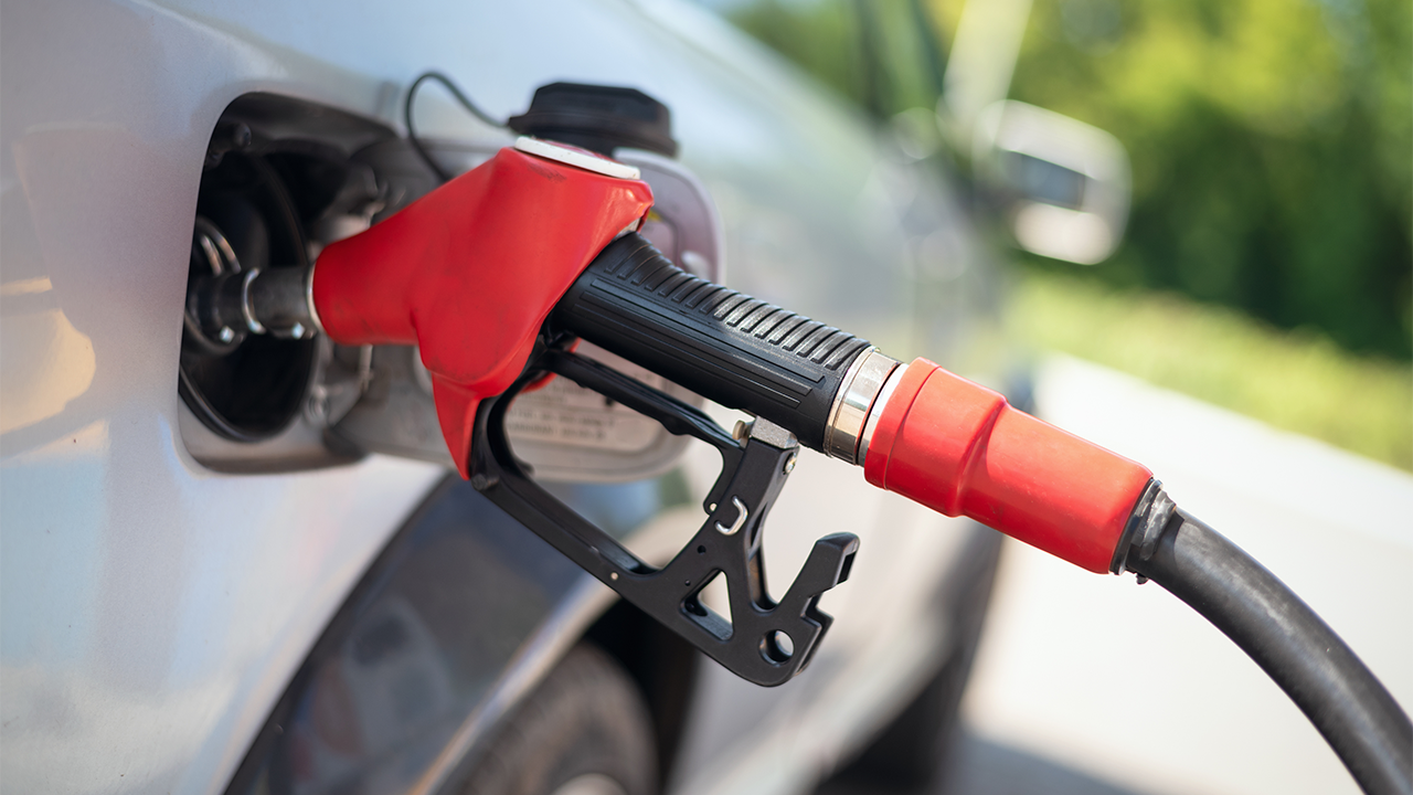 Red gasoline pump connected to gas tank of silver car. source: Shutterstock