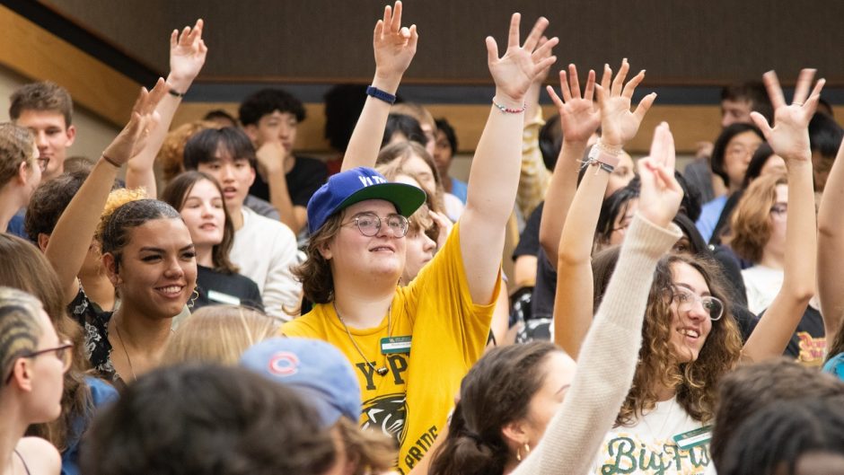 students raising hands in a class