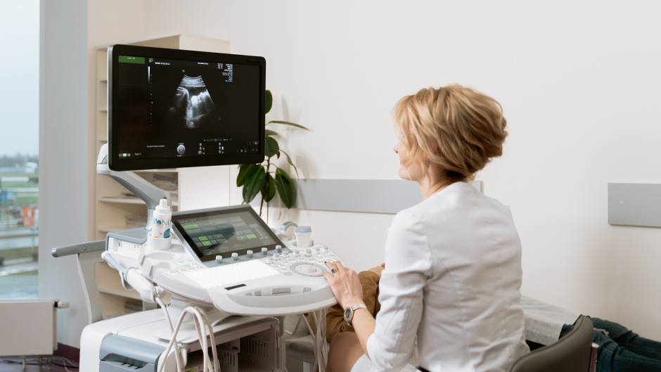 Doctor examines ultrasound scan for pregnant patient.