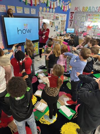 elementary students participating with their teacher